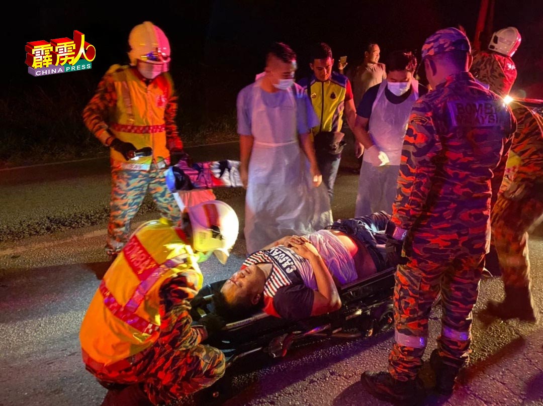 消拯员准备将躺在担架的男伤者，交给救护车送往邻近的医院救治。