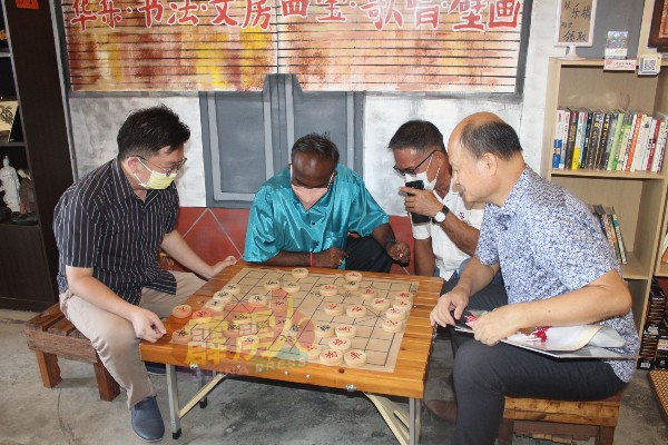 西华古马（中）会上观摩周锦欢（左）与谢保恒（右）的棋局对弈。