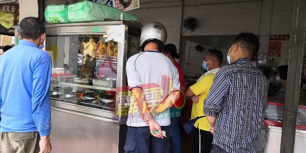 位于怡保乐会居的鸡饭摊，每天都会有许多顾客排队购买鸡饭。