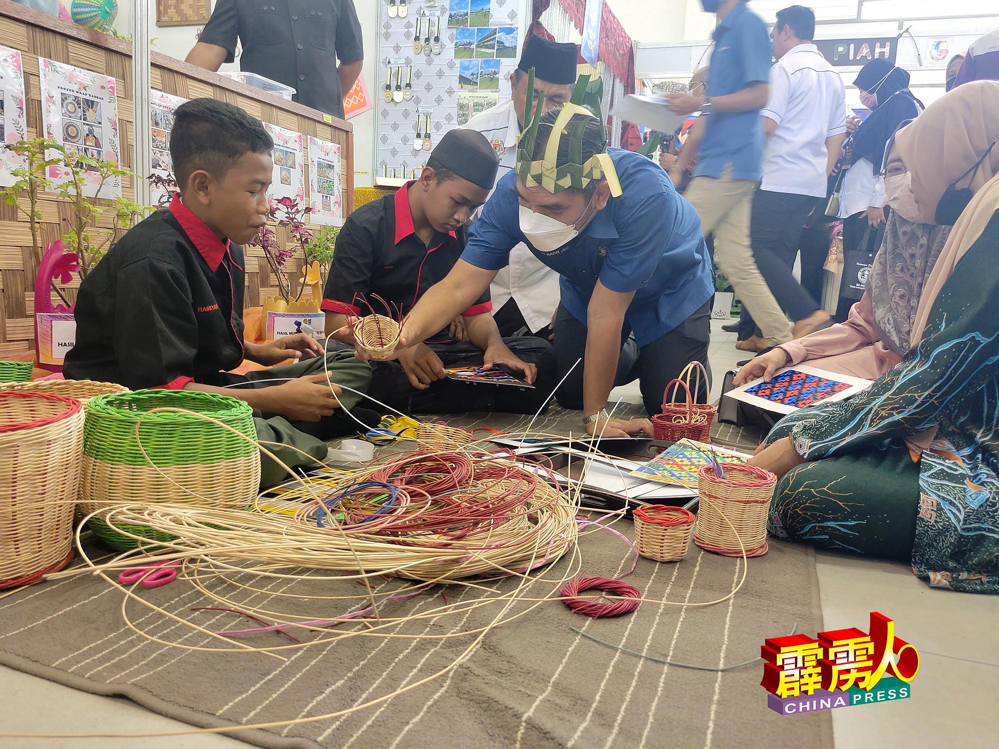 莫哈末拉兹（中）对巴旺中学原住民学生编织的手工艺品，深感兴趣。
