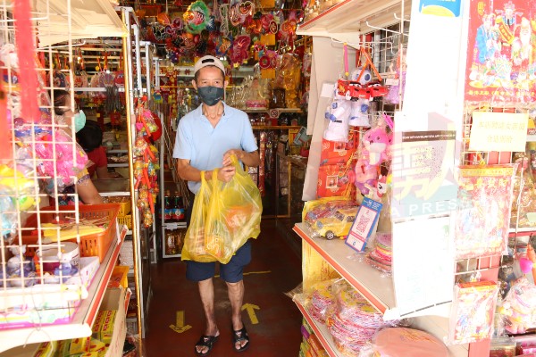 零售商刘先生前往批发店购买灯笼，售卖给当地社区居民。