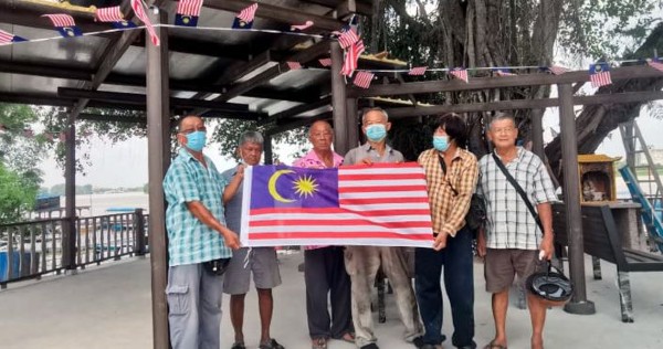 受访者一行人日前趁着国庆月，以国庆主题布置该他们时常相聚的码头。 （取自《马来西亚前锋报》）