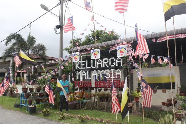 嘉马依据“Keluarga Malaysia Teguh Bersama”国庆主题，装饰其屋旁的小花圃。