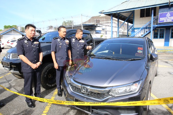李庆泉（左起）、莫哈末尤斯里及阿兹兹展示警方充公的1辆本田轿车及1辆三菱货卡。