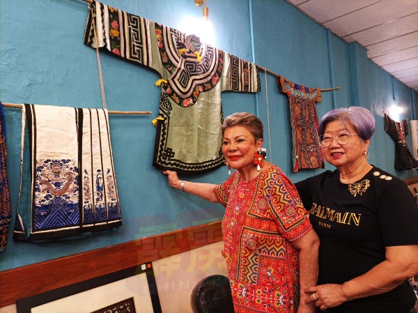 陈喜欢（左）指墙壁上的青色旧礼服，是丝绸制品，被定价为8000令吉，是展览会最贵的物品。右为陈碧金。