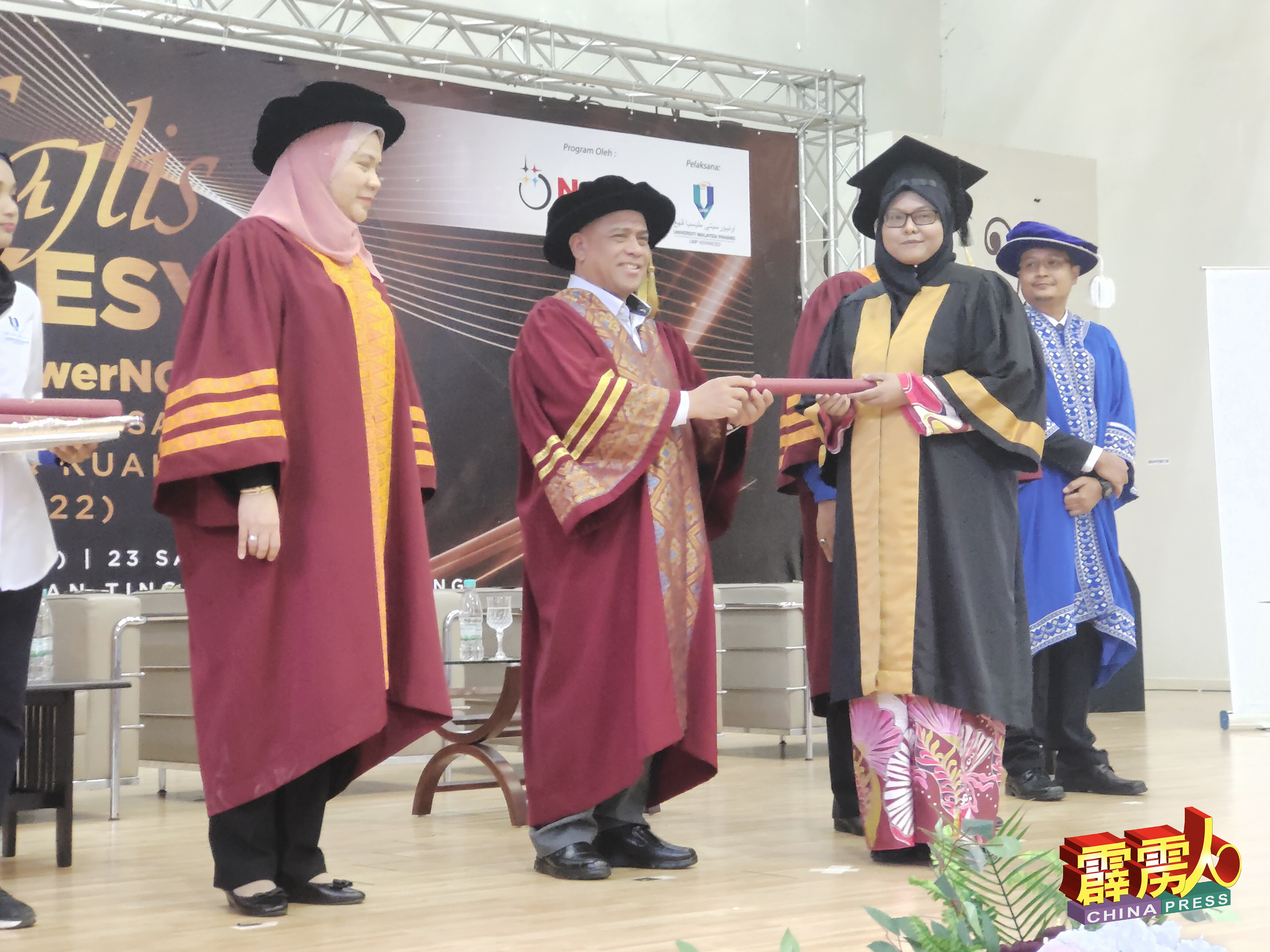 沙拉尼（中）颁发毕业证书给上霹雳其中一名女学生。左为北部经济走廊人事部主任拿汀莎迪。