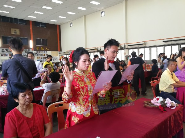 现场唯一一位身穿中式裙褂的新娘甄丽翠与新郎胡文丰在会上进行宣誓。