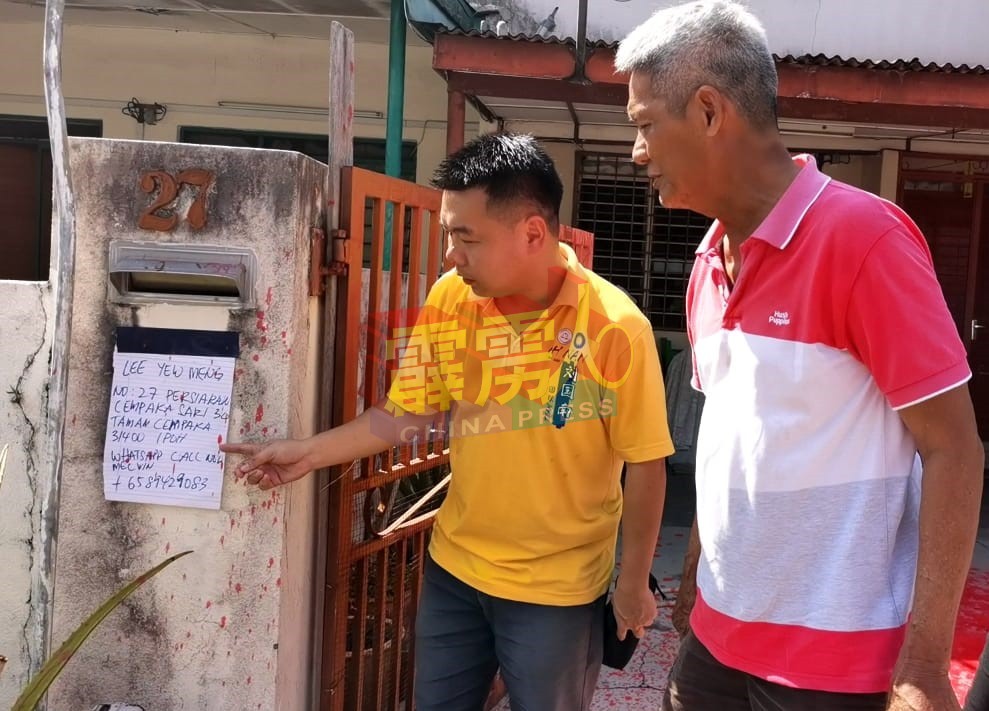 刘国南（左起）与林亚烈查看贴在屋前信箱处的大字报内容。