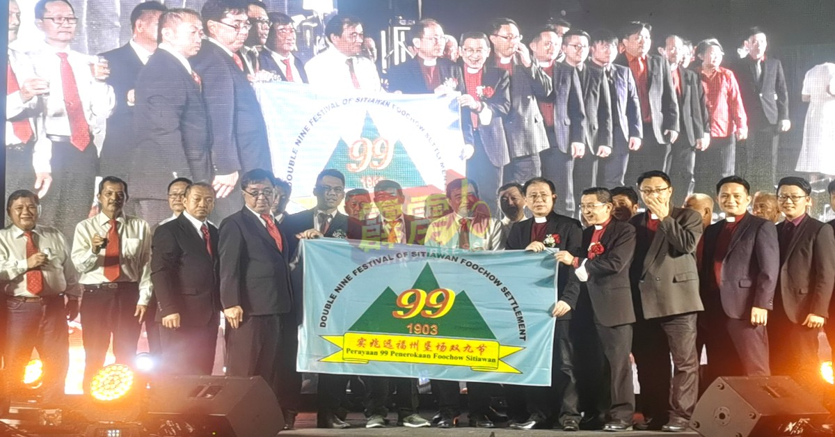 郭进光（前排左5）移交第120届双九节承办旗帜给
廖克民代收。
