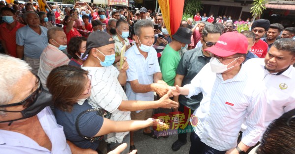 安华（右）抵达拱桥新村时，不忘以华语向村民问好。