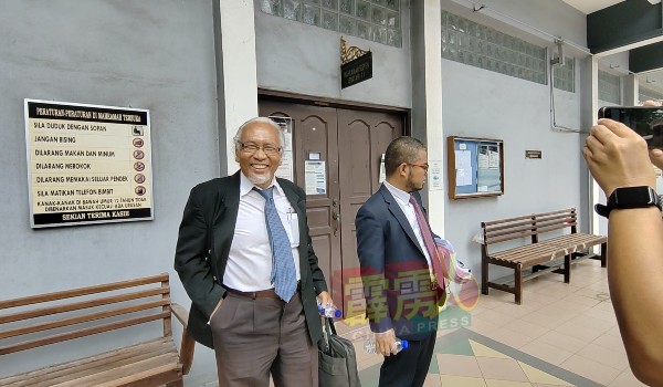 被告辩护律师莫哈末菲特里（右起）及莫哈末阿斯利，成功为被告争取无需缴付罚款后，庭在外向媒体露出胜利的笑容。