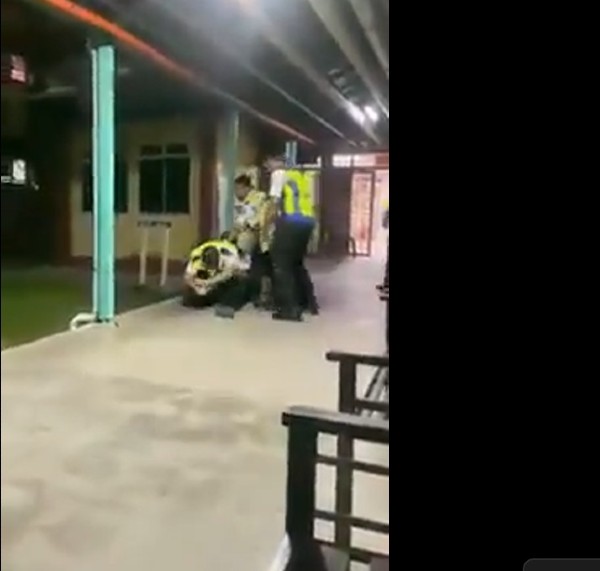 男保安员未知何故瘫坐在地，其他保安员协助扶他起来。（视频截图）