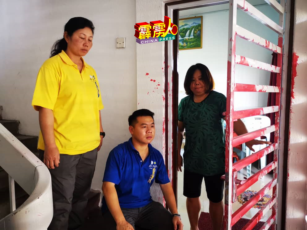 邓女士（右）住家栅门第二度遭泼红漆，向刘国南与团队代表陈枫溦（左）求助。