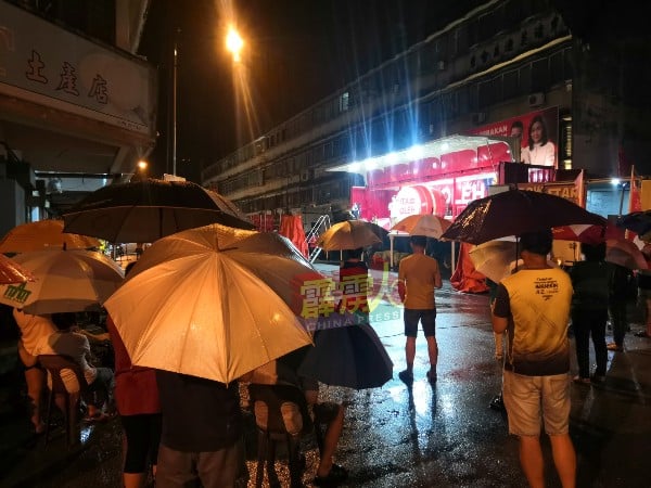 民众撑着雨伞听演讲。