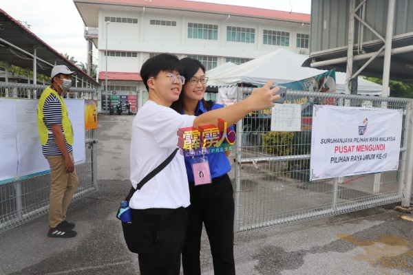 投票后，来张白拍！选民在投票中心外遇见国阵马华务边国席候选人陈昭宋，两人合影留念。