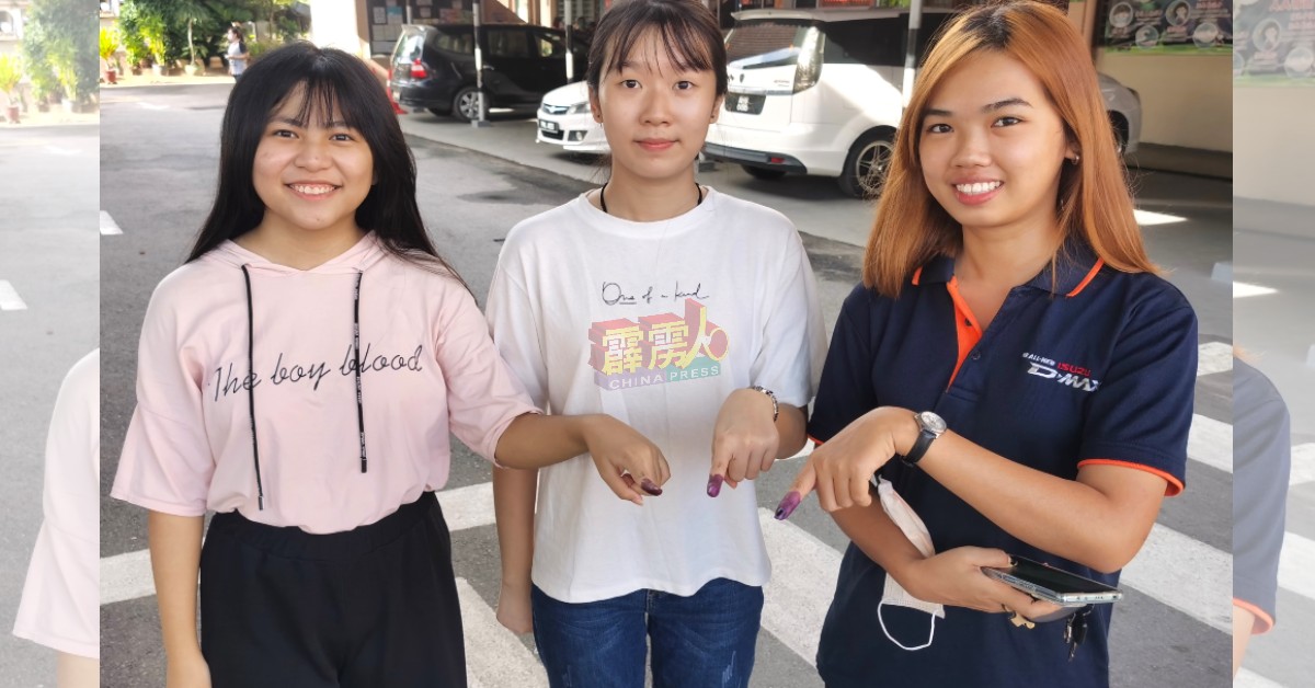 首投族黄晓蓉（左起）、郑洁恩及吴培歆，开心展示首次投票后染色的手指。