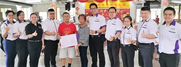 家长丁翠娥（左6）在教练团的陪同下，移交支票给中央福利老人院负责人（左5）。
