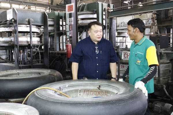 陈仲义（左）向工厂职员跟进生产情况与进度。 