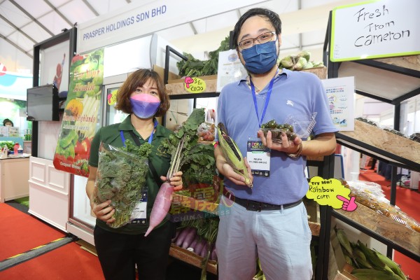 蔡荣征（右）向消费者介绍生物科技技术培育无农药、原始、健康的农产品。
