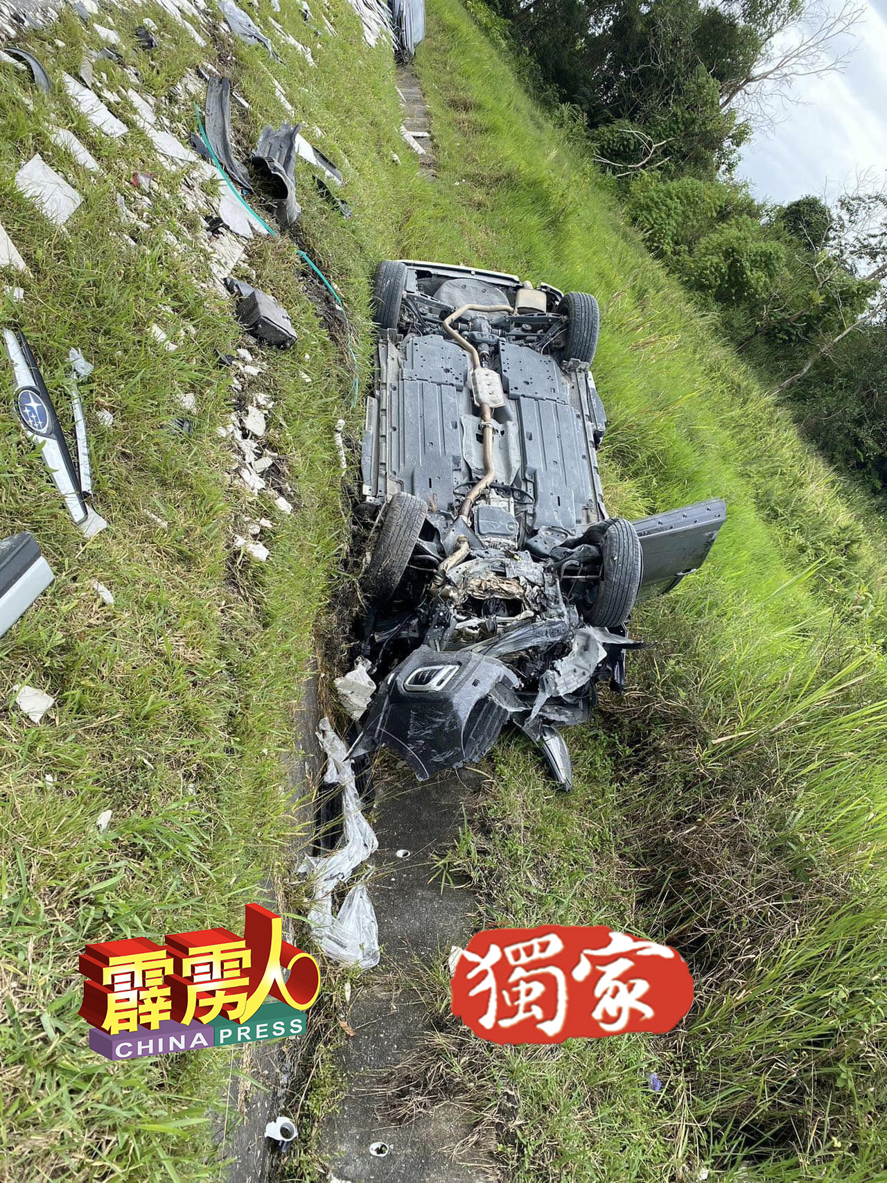 肇祸后，华裔夫妇的Subaru运动型多用途汽车，翻倒在路旁的排水沟处，四轮朝天。
