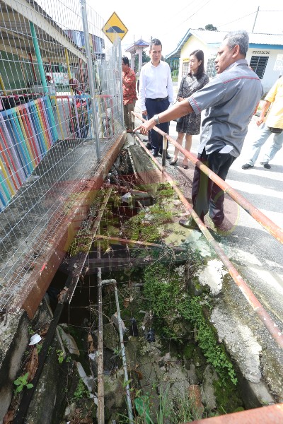 官员所指之处本是水泥围墙篱笆，但在2月被冲毁，教育局改用铁篱笆围上，右2起为古海燕及张哲敏。