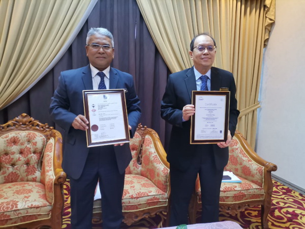 凯鲁阿米尔（左）展示市议会获得国际认证证书。右为秘书卡马鲁查曼。