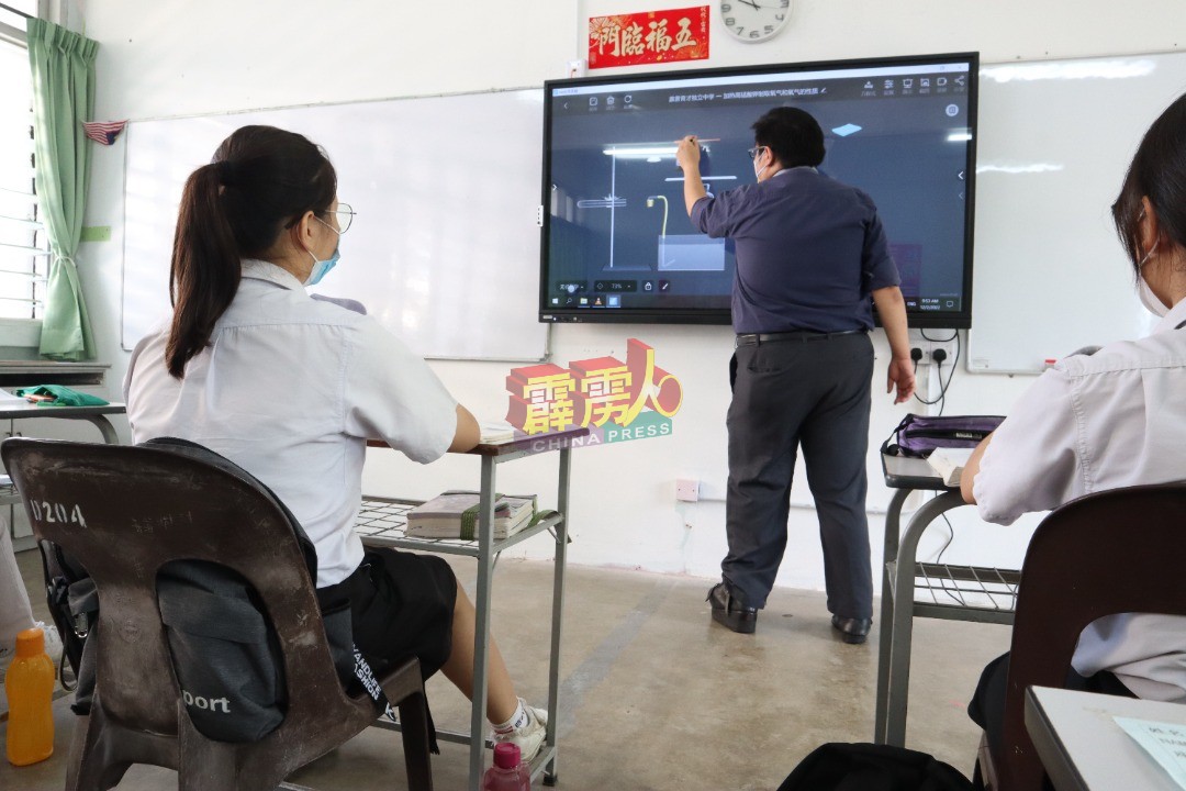 一名老师在课室上，示范如何操作及使用“交互式智能电子白板”教学。