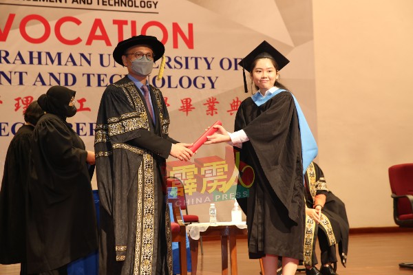 李仕伟（左）颁发毕业证书给毕业生。