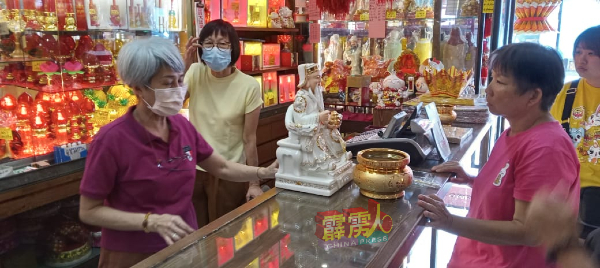 南丰香庄负责人王媚莉（左），向客户讲解各类拜祭品的情况。