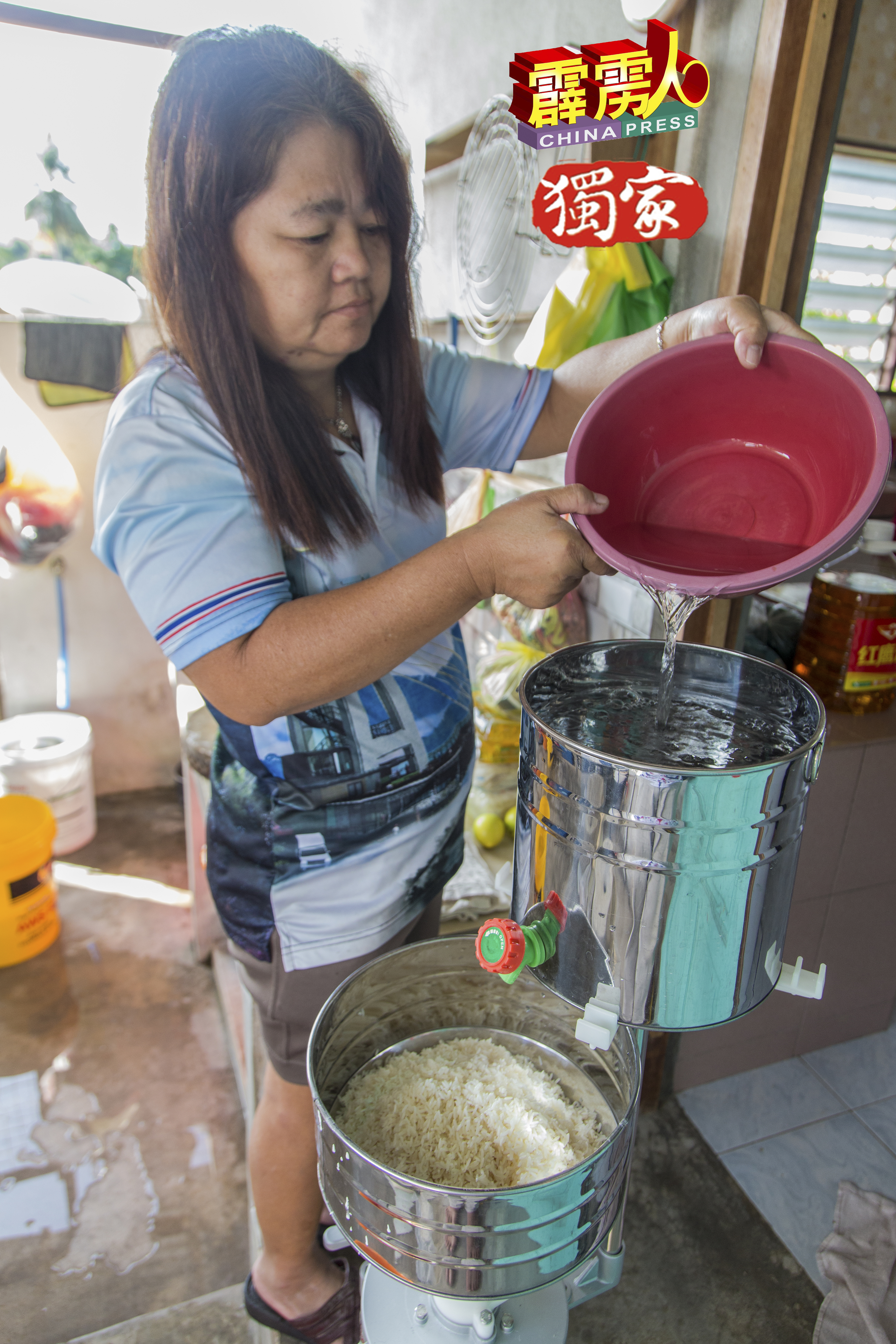 刘银妹先把糯米放入磨米机，再灌水准备磨米。
