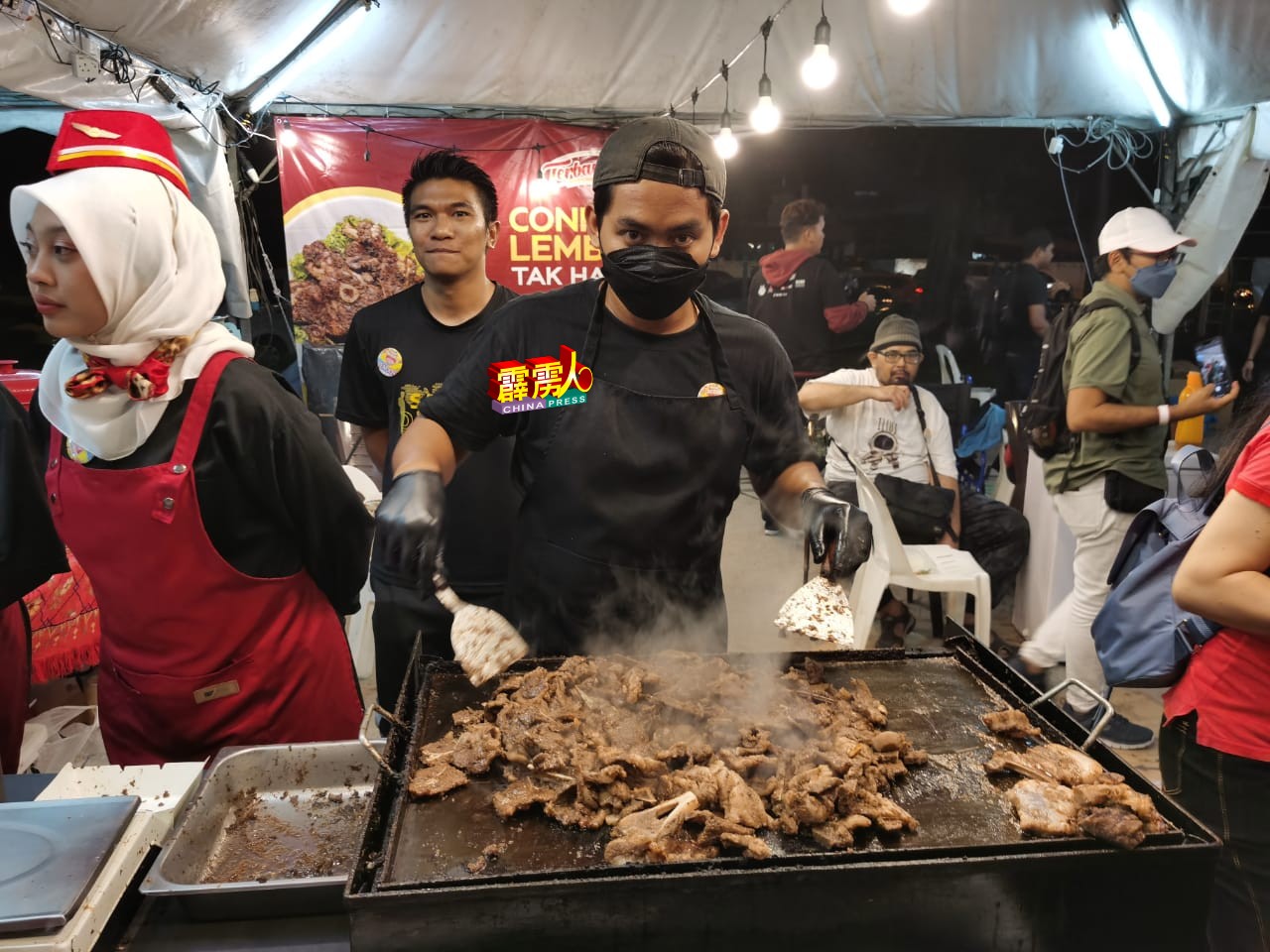 这名厨师在美食展摊位现场烹煮羊肉，令人食指大动。