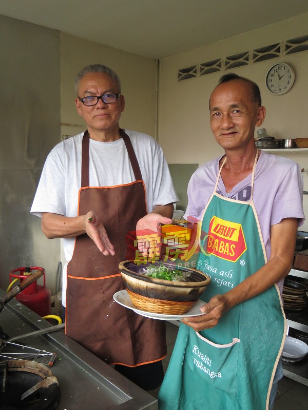 玲珑老合记饭店东主李镇西（左）与其助手陈俊福（右）展示其饭店招牌菜“神仙煲”，味道香浓，美味好吃。 