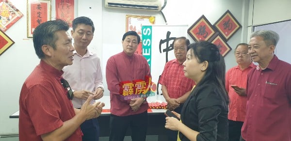 梁爱然（前右起）与黄志伟交流；后排左起为颜登逸丶黄仲贤丶叶建成丶郑东旺及郑庭忠。