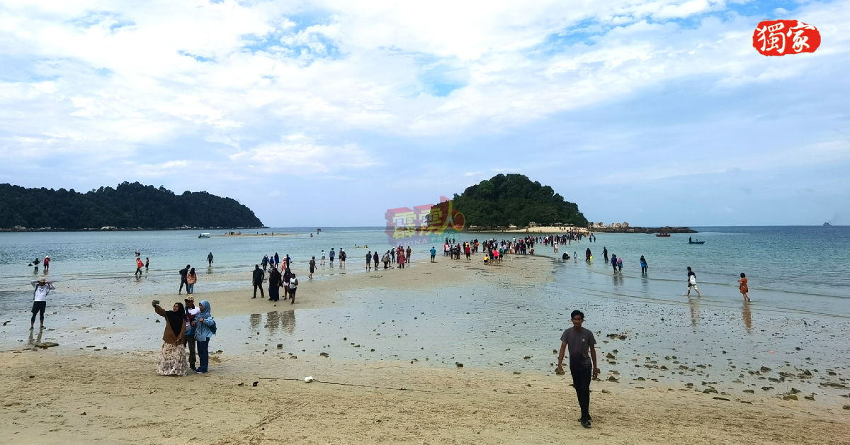 邦咯岛直落尼帕海滩迎来2023年第2次大退潮奇观，数百名游客沿着“海上走道”涉水步行至海中央的珊瑚岛。