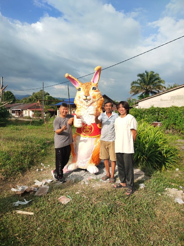 赖伟权（左起）、胡福明与胡延川开心展示刚上完色的吉祥兔。