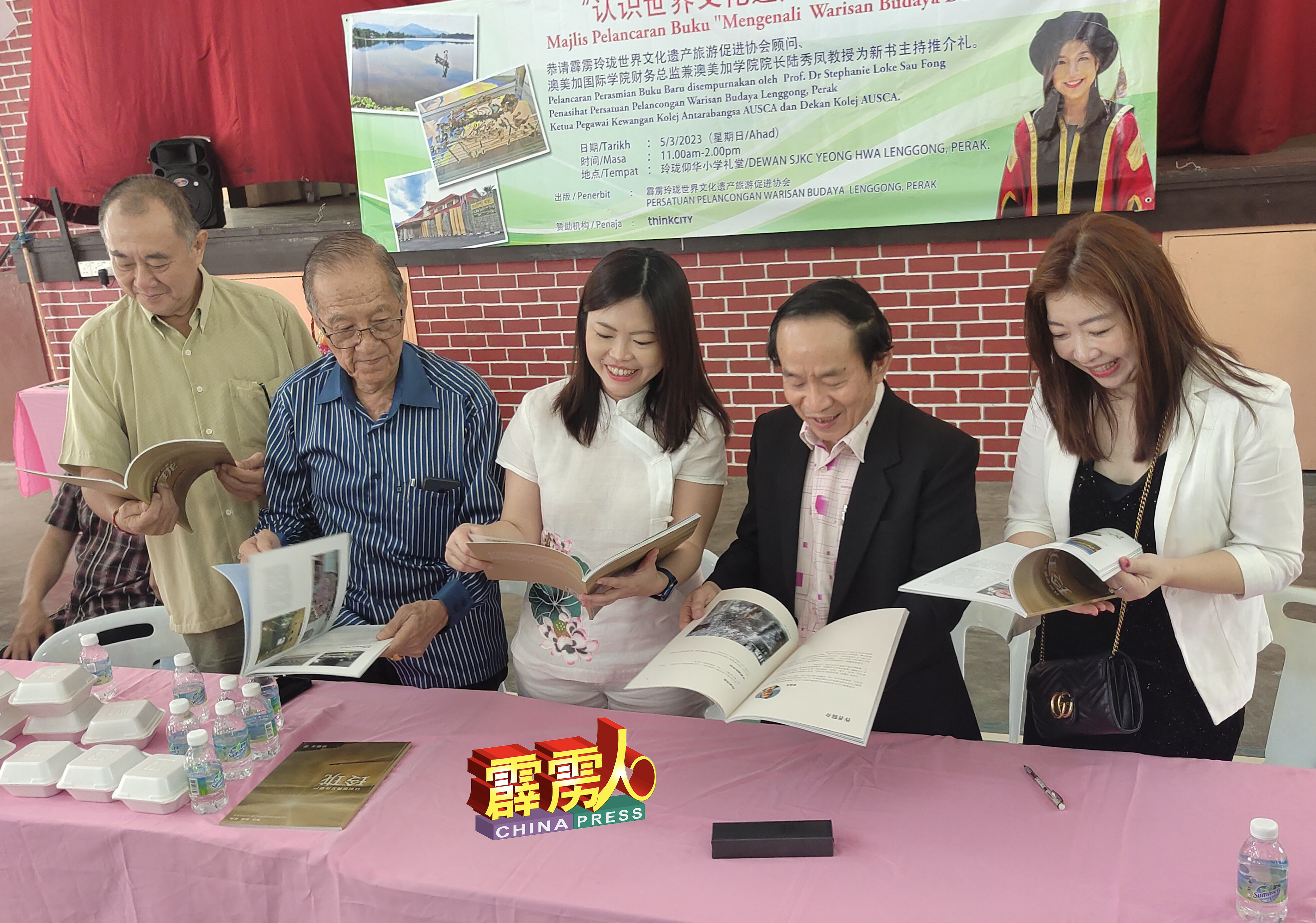 吕国强（左起）、陆镇鸿、梁诗丽、梁雅生及陆秀凤翻阅《认识世界文化遗产-玲珑》著作。