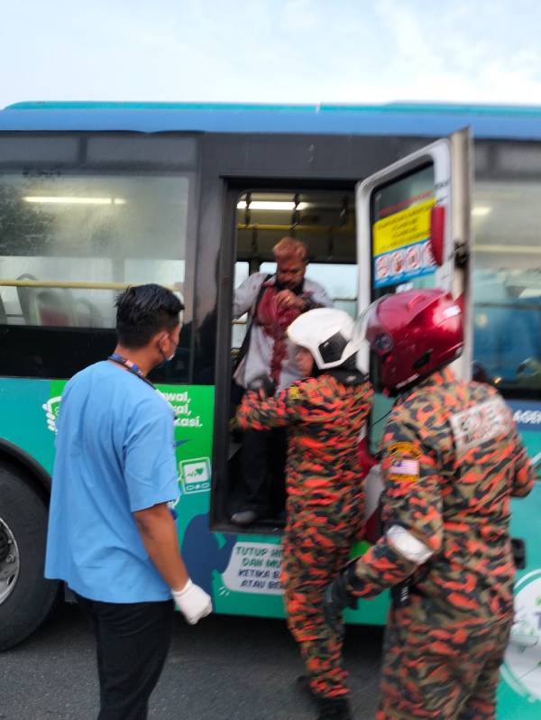消拯员扶伤者下巴士，并交由救护车送往医院接受治疗。