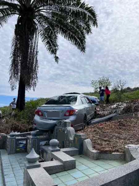 轿车因滑落而不慎撞及坟墓，以致车尾损毁。 （自社媒视频截图）