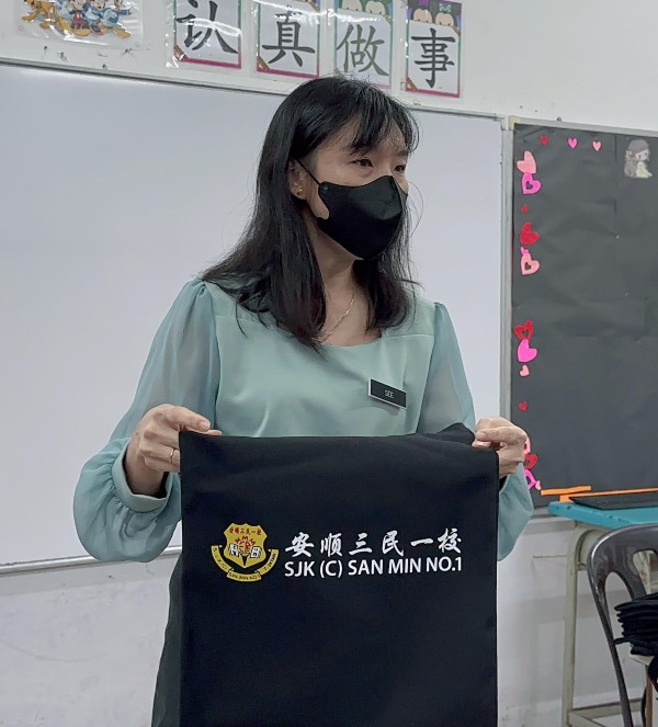 教师展示家协与热心家长赞助的礼袋。