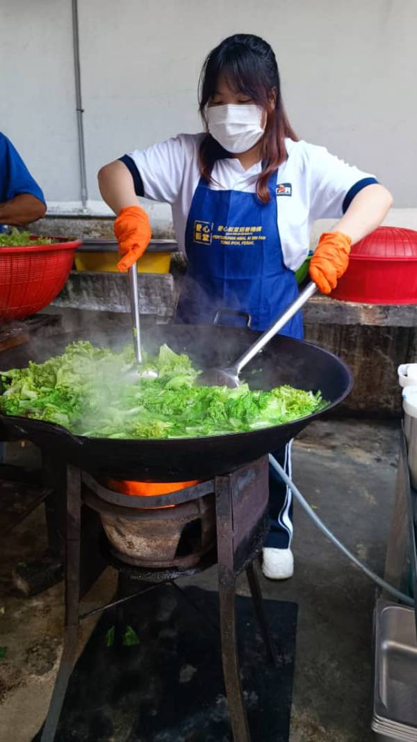 学习如何炒大锅菜的学生，非常有架势。