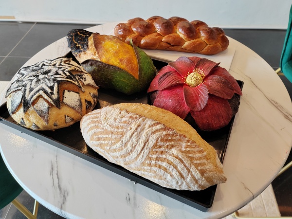面包制作组为比赛所研发的欧式面包及甜面包（辫子面包），当中2款特色欧式面包，以国花大红花及玉米做造型。