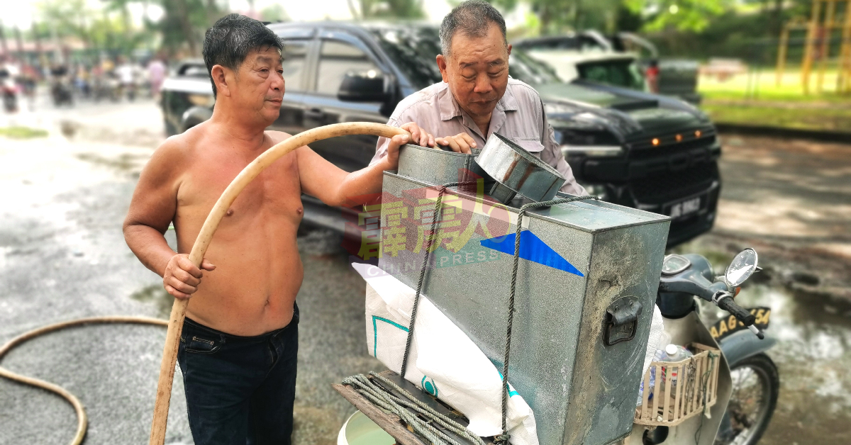 吴新祥（左）为村民带的塑料容器，注入地下水。