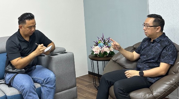 《中国报》高级记者蔡耀梁（左）正在访问郑立慷（右）。