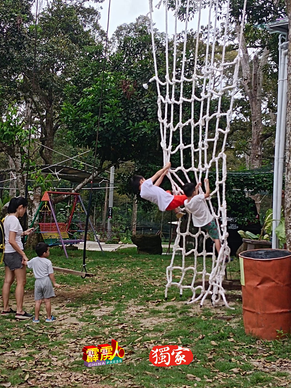 小朋友与家人共同玩起爬网障碍，促进亲子关係。