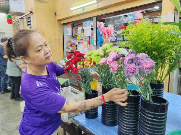 随着母亲节的到来，怡保中央公市花艺业者梁丽君把数盆康乃馨移至门前，吸引民众选购。