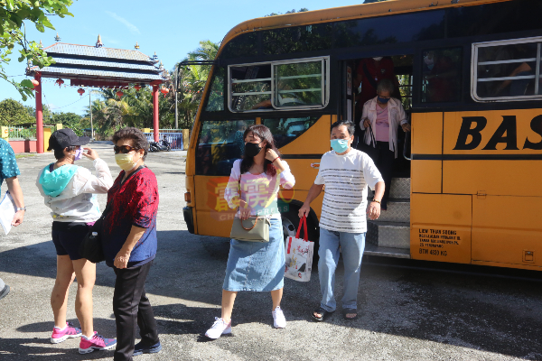 一辆又一辆的巴士，把外地的游客送来心意佛院。