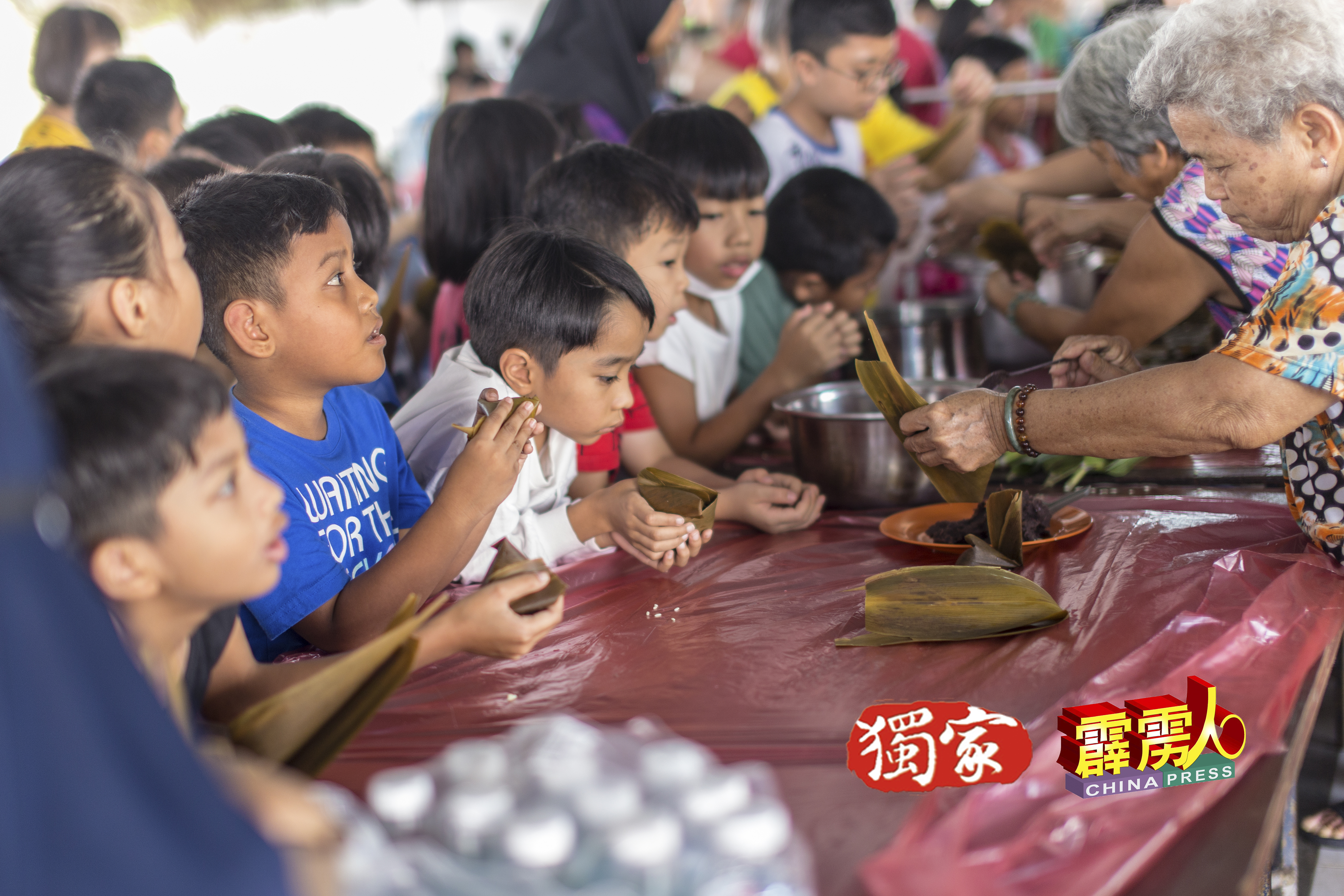“欢庆端午节及双亲节”活动，吸引巫裔、印裔及华裔参与裹粽。