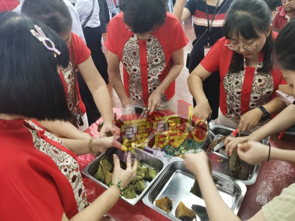 陈素文（右）与妇女组成员一起准备烹好的粽子以供出席的乡亲享用。  