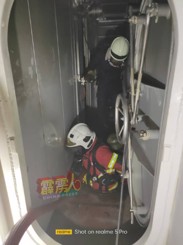 消拯员透过狭窄的通道，进入船舱灭火。