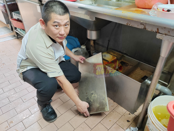 霹雳咖啡茶商公会财政兼怡发咖喱面业者全德强向媒体展示，自己餐馆所安装的的滤油箱，确保食用油不会流入沟渠。